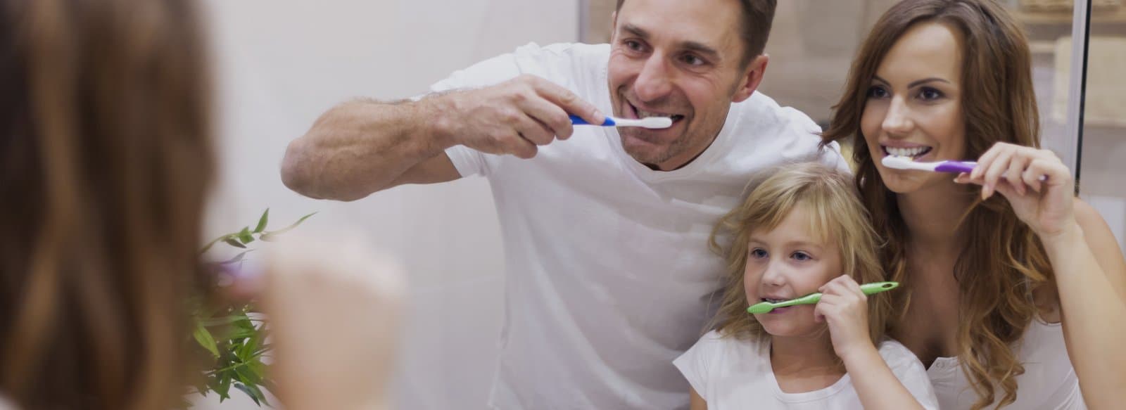 A family brushing their teeth together